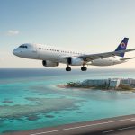 تصویری از هواپیمای سفید در حال پرواز روی ساحل و دریای آبی کیش