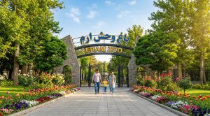 تصویری از در ورودی باغ وحش پارک ارم به همراه درختانی در اطراف آن